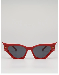 Close-up of red cat-eye sunglasses with bat-wing frames and gold logo details