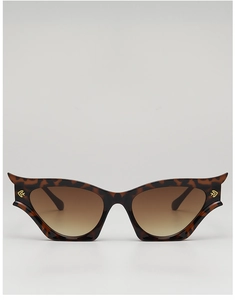Macro detail of tortoiseshell cat-eye sunglasses with golden letter metal decor
