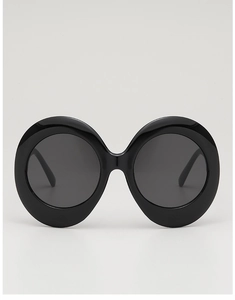 Detailed close-up of glossy black oversized oval frames with dark gray tinted lenses