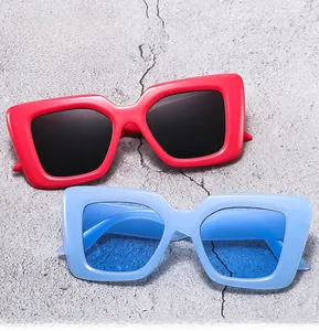 Detailed top view of red and blue square frame sunglasses on a concrete background