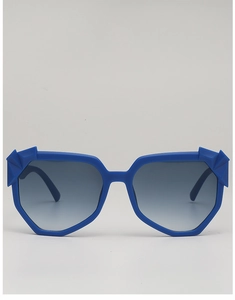 Detail view of blue geometric sunglasses with 3D faceted edges and matte finish frames