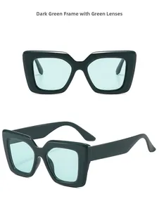Detail view of square oversized dark green sunglasses with mint green lenses