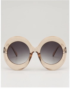 Close-up of translucent champagne oversized oval sunglasses with gradient grey lenses