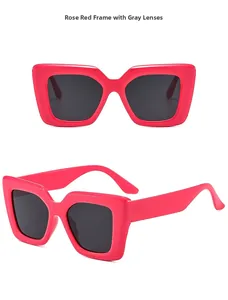 Detail view of large square rose red sunglasses with dark gray lenses and glossy finish
