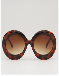 Detailed close-up of retro oversized tortoiseshell frame sunglasses with brown gradient lenses