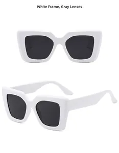 Detailed view of oversized square white sunglasses with thick temples and dark gray lenses