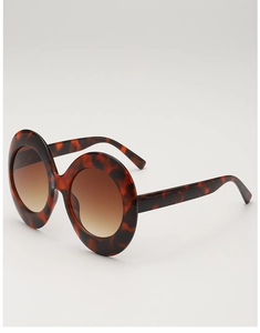 Detailed side view of oversized oval tortoise shell sunglasses with gradient brown lenses