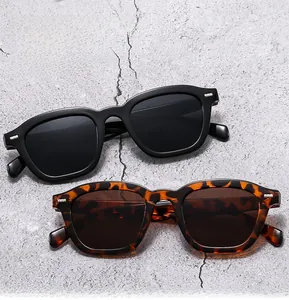 Detail of square sunglasses in glossy black and leopard print with metal studs