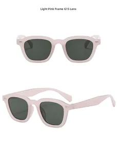 Detail view of square light pink translucent sunglasses with green G15 lenses and rivets