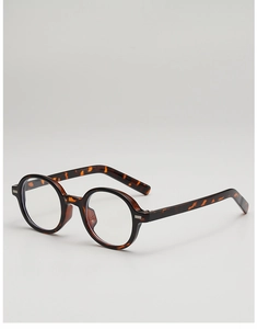 Detail view of oval tortoise shell sunglasses with retro amber texture and metal rivets