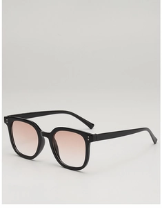 Close-up of black square sunglasses with gradient pink lenses and silver stud details