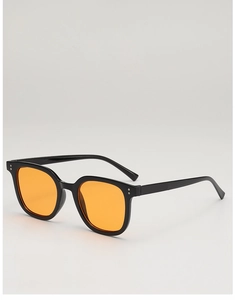 Close-up of square black frame sunglasses with yellow lenses and silver rivet detail