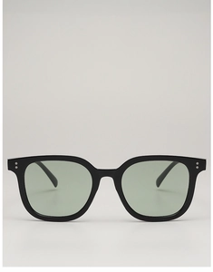Detail view of square black frames with silver rivets and grey-green lenses