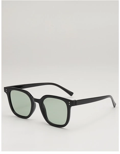 Close-up of retro square black frames with mint green lenses and silver rivet details