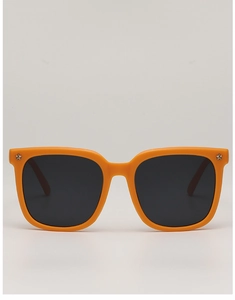 Detail of bright orange kids sunglasses with silver star rivets on a glossy frame