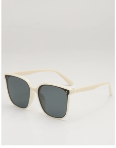 Close-up of cream square frame sunglasses with dark grey lenses and metal accents