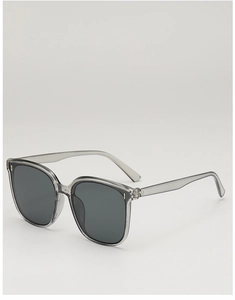 Close-up of translucent grey square sunglasses with metal rivets and dark lenses