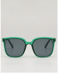 Detail of translucent emerald green oversized sunglasses with metallic accents