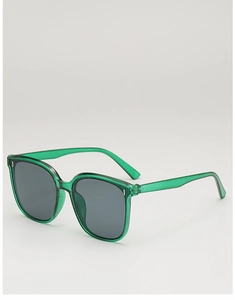 Close-up of translucent green square sunglasses with metal rivet details and dark lenses