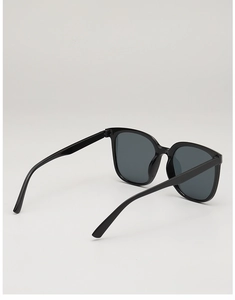 Detail view of the sleek black frames and dark lenses on these square oversized sunglasses