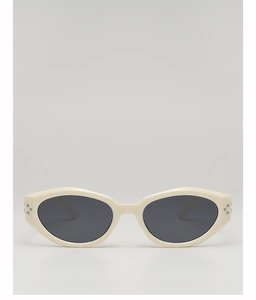 Détail de lunettes de soleil rétro crème avec verres UV et rivets argentés décoratifs