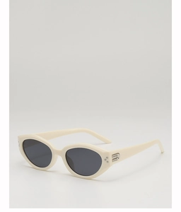 Détail de lunettes de soleil œil-de-chat vintage avec monture crème et logo en métal argenté