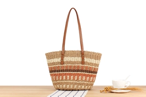 Détail du sac cabas en paille tressée colorée avec poignées en cuir et rayures