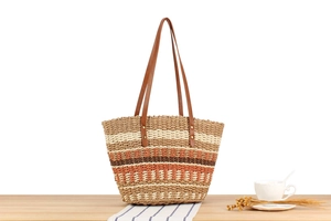 Détails de texture du sac cabas en paille rayé avec anses en cuir marron