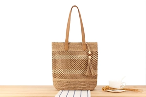 Détail du sac cabas en paille tissé avec maille évidée et anses en cuir marron