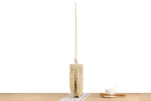 Close-up of beige woven straw handbag with long strap on a table for summer beach style