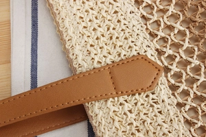 Détail de la texture du sac en paille tressée avec maille beige et point évidé brun