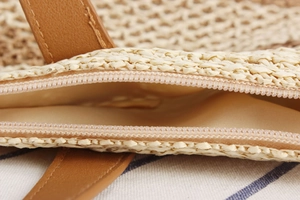Gros plan détaillé d'un sac de plage tressé avec fermeture éclair et doublure en coton