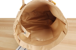 Vue détaillée de l'intérieur d'un sac en paille avec doublure et fermeture éclair