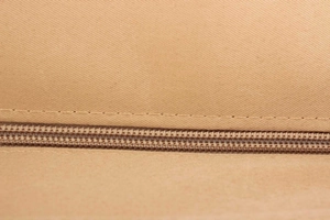Gros plan sur la fermeture éclair en nylon et la couture robuste du sac fourre-tout tissé