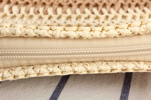 Detailed close-up of woven straw texture with durable nylon zipper and inner lining