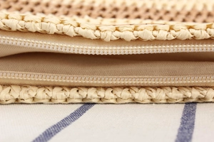 Detailed macro view of nylon zipper closure and soft lining on the woven beach handbag