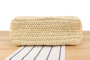 Detailed close-up of natural straw woven texture and hollow-out mesh on a beige beach bag