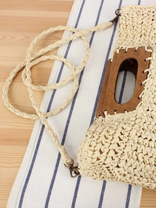 Handmade beige woven straw bag with dark oval wooden handle and matching shoulder strap