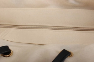 Detail shot of sturdy woven fabric tote bag with zipper closure and black leather strap