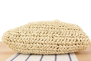 Detailed view of handmade woven straw bag texture with beige crochet pattern for summer