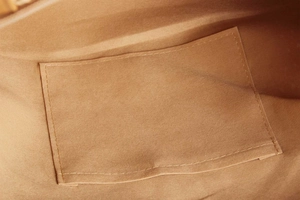 Detailed macro view of the inner lining and rectangular pocket on the woven canvas tote