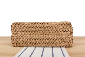 Detailed macro view of handcrafted woven straw tote bag texture and reinforced base