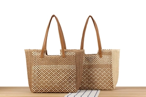 Detail der handgewebten Strohtasche mit Streifenmuster und Ledergriffen für den Strand