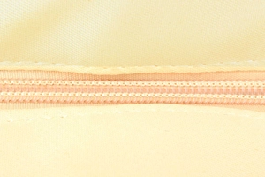 Close-up of internal zipper pocket with neat stitching on cream woven shoulder bag