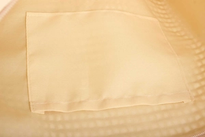 Detail of internal lining and rectangular inner pocket made of thick beige canvas fabric