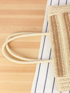 Large woven beach bag in light beige and brown tones on a rustic wooden table background