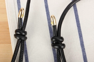 Detail of black pebbled leather drawstring with gold hardware and yellow accents