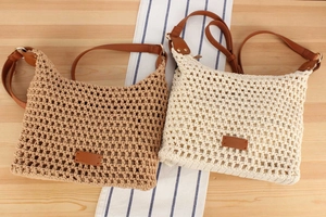 Detailed close-up of woven straw shoulder bags in khaki and beige with leather straps