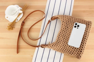 Detail of hand-woven crochet bag with adjustable leather strap and mesh texture