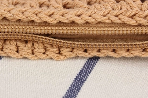 Close-up of woven straw bag showing the tight weave texture and durable nylon zipper detail